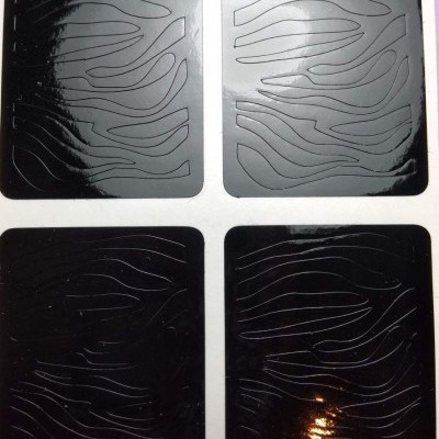 Conjunto de quatro placas quadradas com textura ondulada, duas brancas e duas pretas.