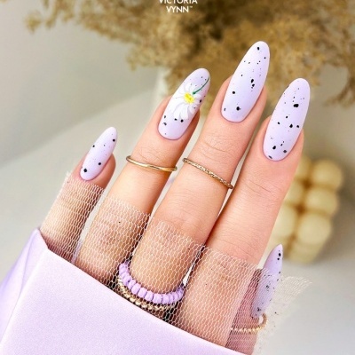 Unhas lilás decoradas com manchas e flores, aneis dourados, rede transparente e logotipo VICTORIA VYNN