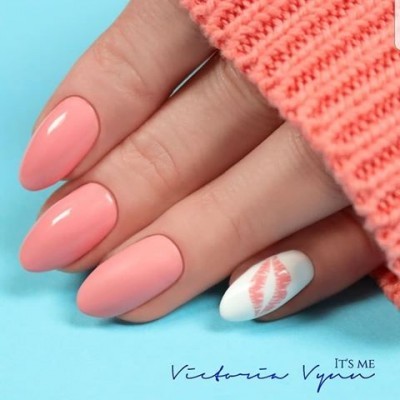 Unhas cor de coral com decoração de lábios em fundo branco e manga rosa