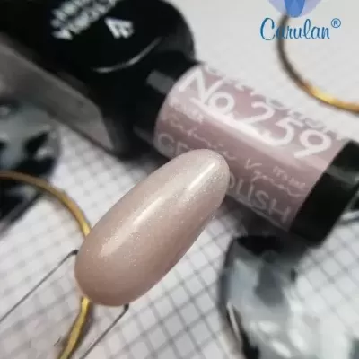 Esmalte de unhas bege perolado com glitter e frasco preto com rótulo rosa no fundo quadriculado