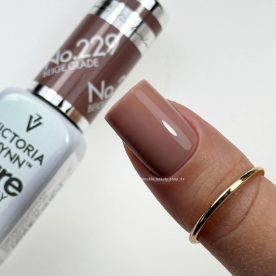 Esmalte de unhas Victoria Vynn cor bege No. 229 aplicado em unha quadrada com anel dourado.