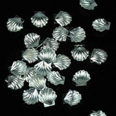 Miçangas prateadas em forma de concha sobre fundo preto