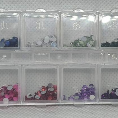 Caixa organizadora com pedras de strass coloridas em compartimentos numerados