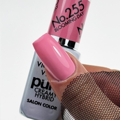 Frasco de verniz com rótulo rosa e unha pintada de rosa brilhante