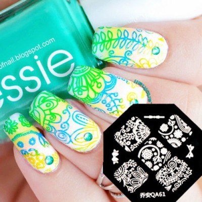 Unhas decoradas com padrão floral colorido e frasco de verniz Essie verde.