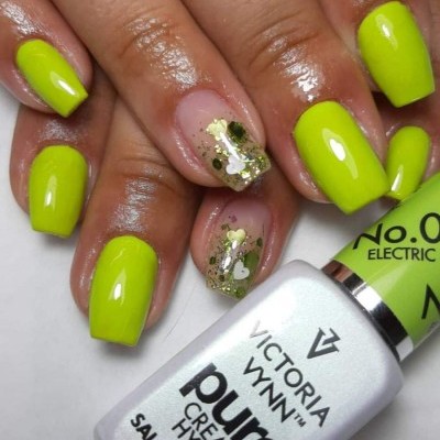 Unhas pintadas de verde fluorescente com decoração em glitter e frasco de verniz Victoria Vynn.