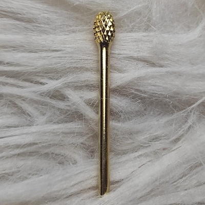 Broca de corte dourada sobre superfície branca fofa