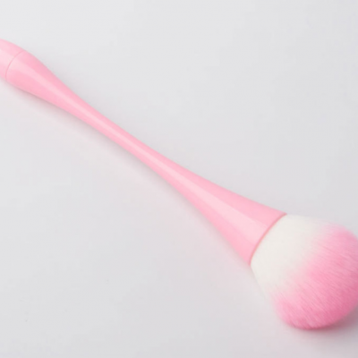Pincel de maquilhagem rosa com cerdas brancas e rosa sobre fundo branco.