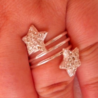 Anel prateado aberto com estrelas brilhantes