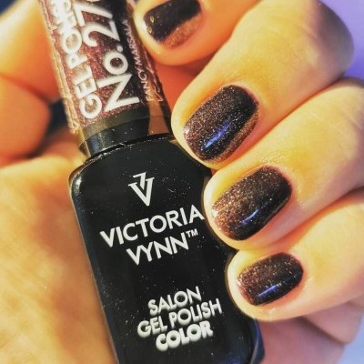 Frasco de verniz gel preto com brilho e unhas pintadas à mão