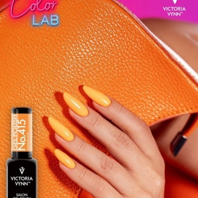 Unhas pintadas de laranja com frasco de verniz Victoria Vynn e bolsa laranja num fundo cor-de-rosa