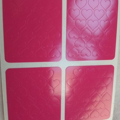 Placas quadradas rosa com padrão em relevo de corações.