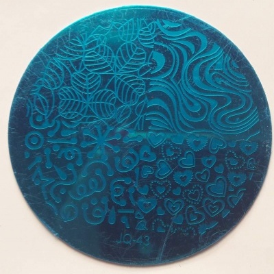 Placa metálica circular azul com padrões em relevo para carimbos de unhas.