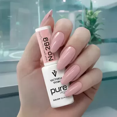 Unhas longas pintadas de rosa segurando frasco de verniz Victoria Vynn