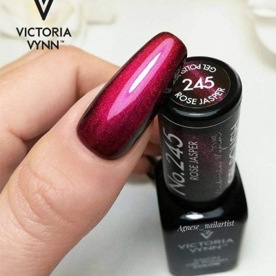 Unha longa pintada com esmalte vermelho brilhante segurando frasco de esmalte preto Victoria Vynn