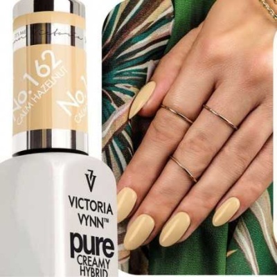 Frasco de verniz VICTORIA VYNN Cor No. 162 Canary Hazelnut e mão com unhas pintadas na mesma cor