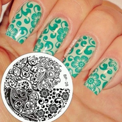 Unhas com padrão floral verde e placa de estampa BP-28 com desenhos florais pretos