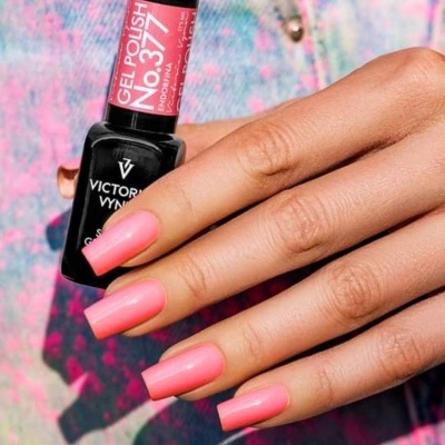 Mão com unhas pintadas de verniz gel rosa segurando frasco de verniz gel No. 377 Endorfina da Victoria Vynn