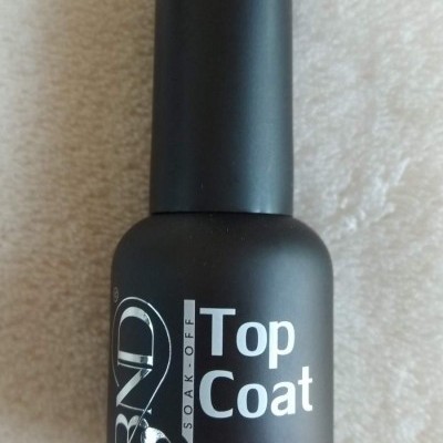 Frasco preto fosco de verniz de unhas CND Top Coat 10ml sobre superfície clara