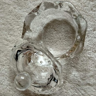 Frasco de vidro transparente com tampa redonda sobre tecido bege