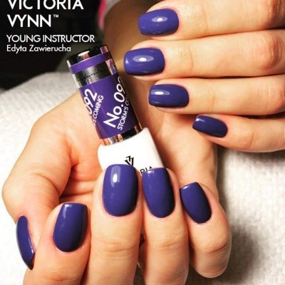 Unhas pintadas de roxo brilhante com frascos de verniz Victoria Vynn