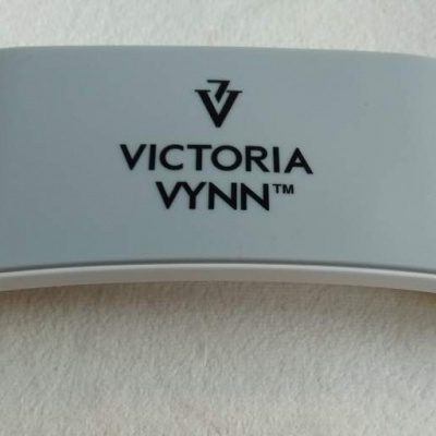 Dispositivo plástico branco e cinzento com o texto VICTORIA VYNN™