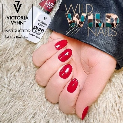 Mão com unhas vermelhas e frascos de verniz Victoria Vynn