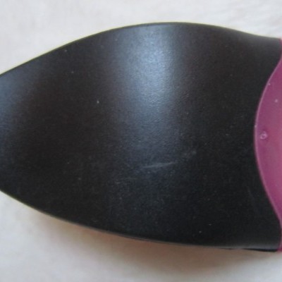 Objeto plástico preto e rosa em fundo branco