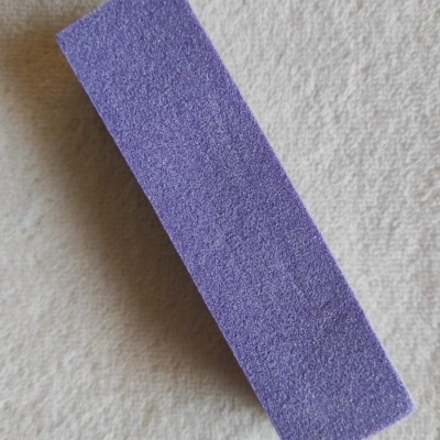 Bloco de lixagem roxo sobre tecido claro