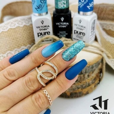 Mão com unhas azuis decoradas e vernizes Victoria Vynn ao fundo