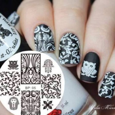 Unhas decoradas com padrões preto e branco variados, incluindo corujas e símbolos artísticos.
