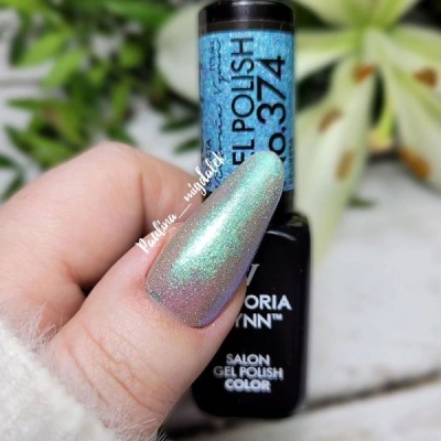 Frasco de verniz gel preto com tampa azul brilhante e texto segurado por mão com unha comprida pintada de verniz iridescente