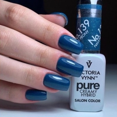 Unhas pintadas de azul escuro brilhante segurando verniz Victoria Vynn