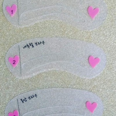 Três moldes transparentes numerados com corações cor-de-rosa em superfície prateada