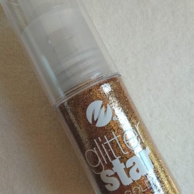Frasco de glitter líquido dourado rotulado com texto e tampa transparente