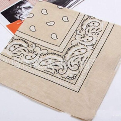 Lenço bege com padrão preto em forma de gotas e arabescos sobre revistas