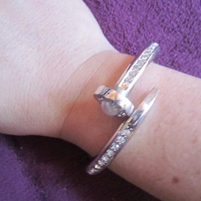 Pulseira prateada com pedras brilhantes usada no pulso