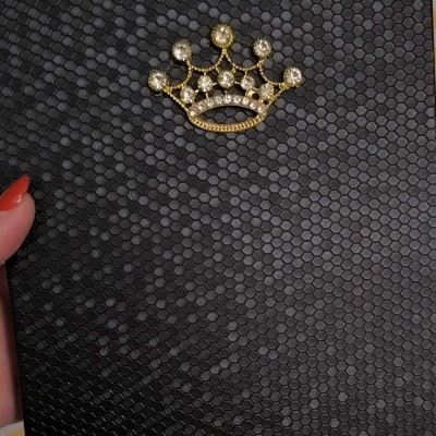 Capa preta texturizada com coroa dourada e pedras brilhantes