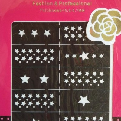 Autocolantes para arte de unhas com estrelas brancas em fundo preto na embalagem rosa com texto dourado