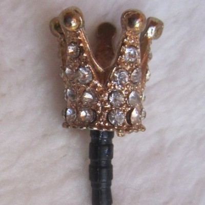 Pingo anti-poeira dourado em forma de coroa com pedras brilhantes