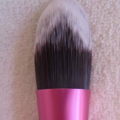 Pincel de maquilhagem com cerdas pretas e brancas e pega rosa