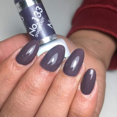 Frasco de verniz de unhas e unhas pintadas em tom roxo acinzentado