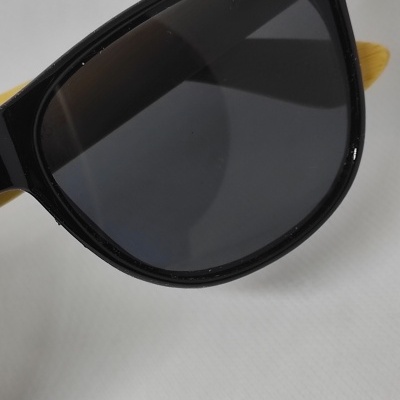 Óculos de sol com armação preta e lentes escuras sobre fundo branco