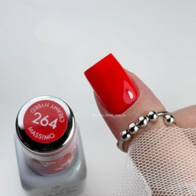 Frasco de verniz vermelho 264 MASSIMO CREAMY HYBRID e unha pintada de vermelho com anel prateado e rede branca.