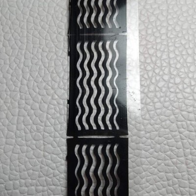 Três folhas pretas com padrões de ondas prateadas sobre fundo branco.