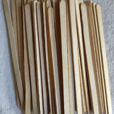 Palitos de madeira claros e arredondados sobre superfície branca