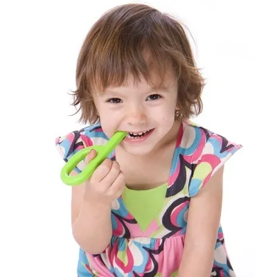 Mordedor ARK's Grabber® liso Criança com vestido colorido segurando brinquedo verde em fundo branco