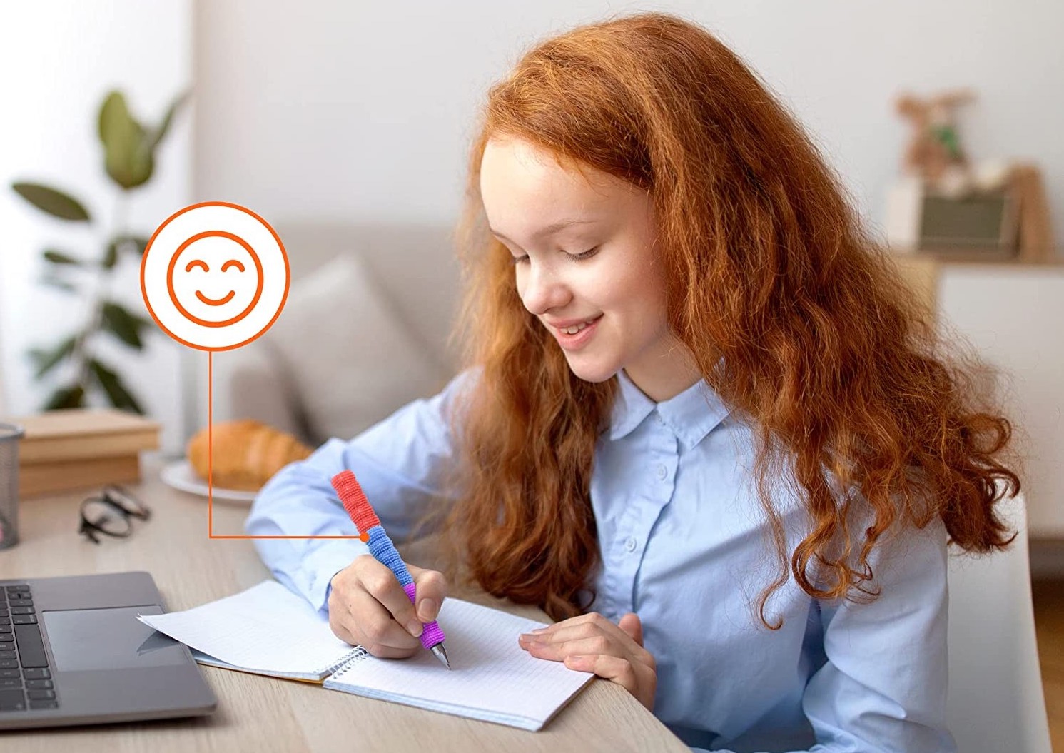 Adaptador para lápis texturizado Criança ruiva a escrever num caderno aberto numa secretária com computador e planta.