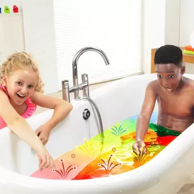 Banho Sensorial - Zimpli Crackle Baff Colours Duas crianças numa banheira branca com cobertor colorido com padrões florais