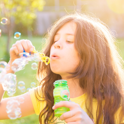 Criança a soprar bolhas de sabão ao ar livre